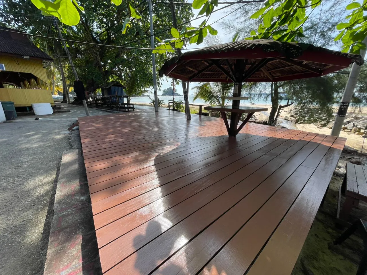 Wooden deck with umbrella and trees